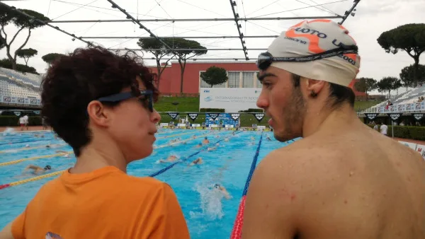 Francesca Valori con un atleta a bordo vasca durante una gara di nuoto
