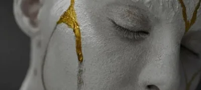 Volto in stile kintsugi con crepe dorate, simbolo di trasformazione e cura di sé