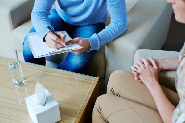 Persona che ascolta e prende appunti durante un colloquio di sostegno psicologico